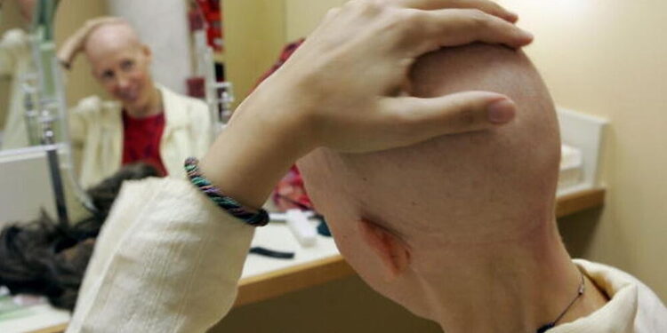 SAN FRANCISCO - AUGUST 17:  Breast cancer patient Susanne Ostlund rubs her head before trying on a wig at the Friend to Friend store at the UCSF Comprehensive Cancer Center August 17, 2005 in San Francisco, California. The UCSF Comprehensive Cancer Center continues to use the latest research and technology to battle cancer and was recently rated 16th best cancer center in the nation by US News and World Report. (Photo by Justin Sullivan/Getty Images)